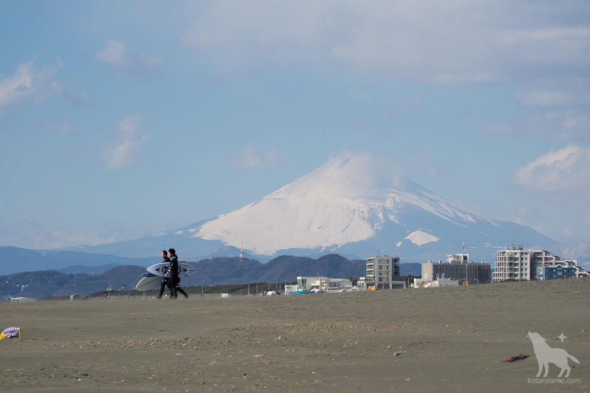 冠雪した富士山とサーファー
